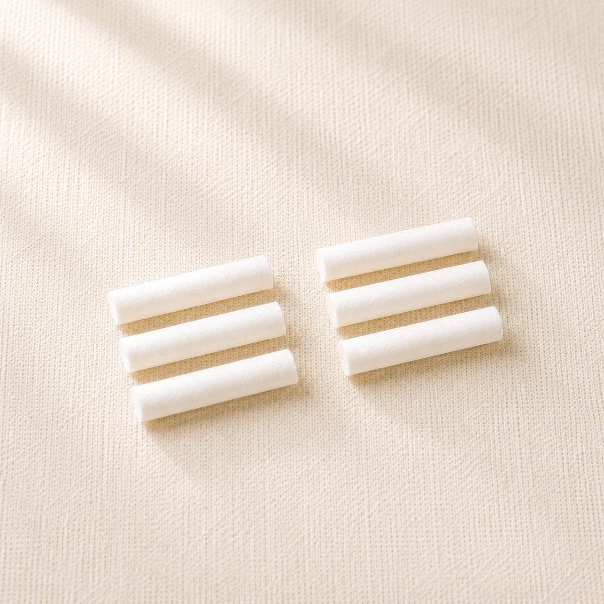 Six dry cotton sticks on cream linen, supplied as two sets of three.