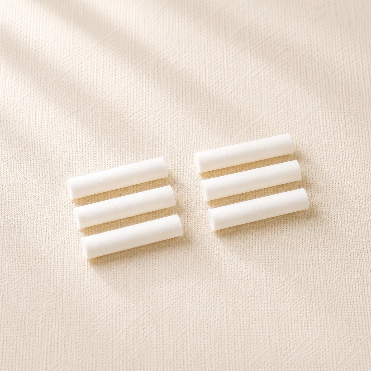 Six dry cotton sticks on cream linen, supplied as two sets of three.